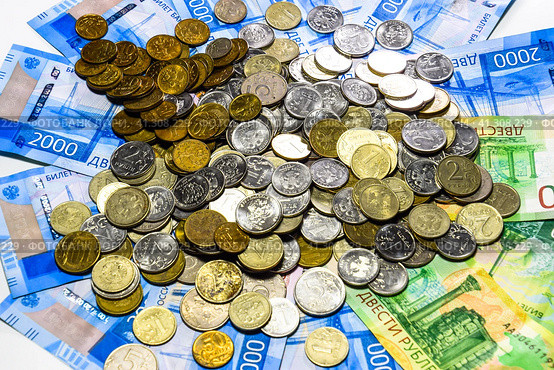 Russian banknotes and coins. A handful of coins on new Russian banknotes in denominations of 2000 and 200 rubles. Стоковое фото, фотограф Леонид Еремейчук / Фотобанк Лори