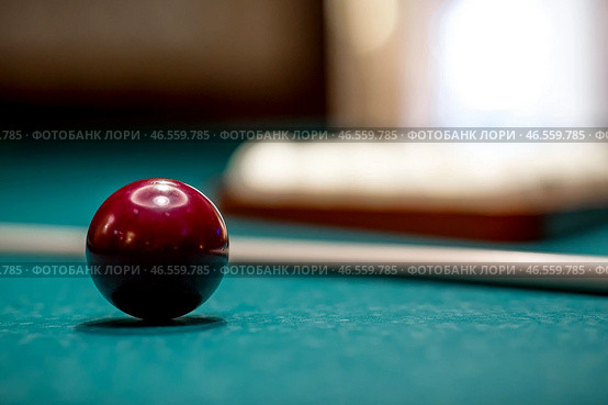 Russian billiards. Red and white balls are lying on a green billiard table. Spending time at home playing a hobby sports game. Стоковое фото, фотограф Photojuli / Фотобанк Лори