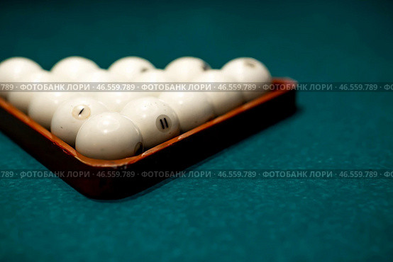 Russian billiards. Red and white balls are lying on a green billiard table. Spending time at home playing a hobby sports game. Стоковое фото, фотограф Photojuli / Фотобанк Лори
