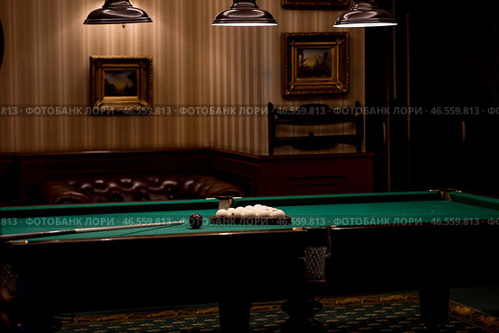 Russian billiards. Red and white balls are lying on a green billiard table. Spending time at home playing a hobby sports game. Стоковое фото, фотограф Photojuli / Фотобанк Лори