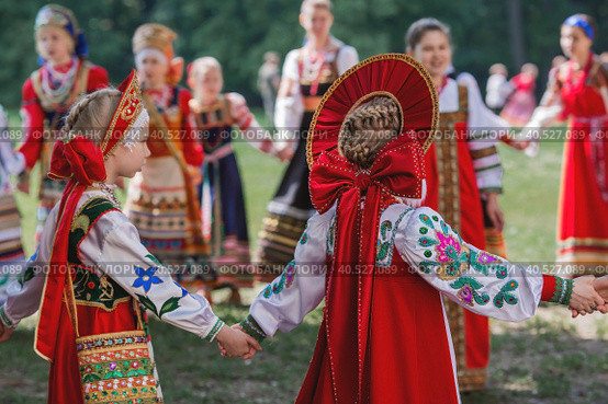 Russian folk traditions. Folk festivals. Children in beautiful Russian traditional outfits sing songs, dance and lead a round dance in Tsaritsyno Park. National Russian clothes. Sundresses and kokoshniks. (2023 год). Редакционное фото, фотограф Photojuli / Фотобанк Лори