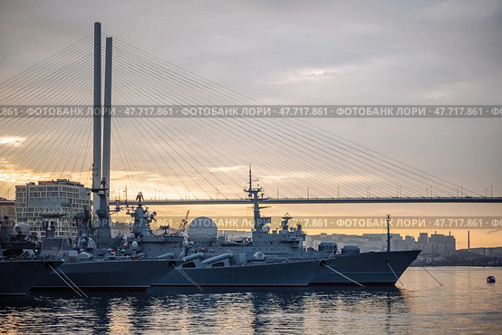 Russian navy warships mooring near zolotoy rog bridge during golden sunset, highlighting naval presence in vladivostok harbor. Стоковое фото, фотограф Mikhail Davidovich / Фотобанк Лори