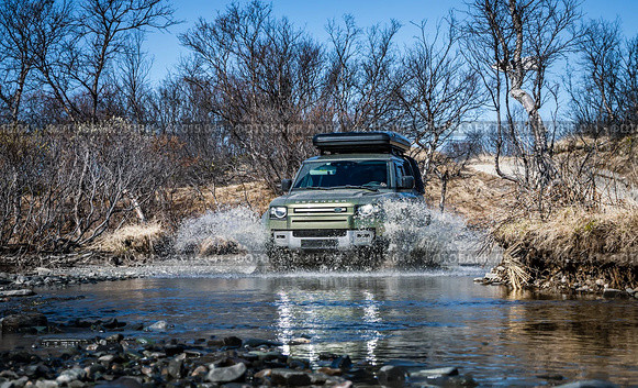 Rybachy, RUSSIA - May 30 2022: Off-roading New Land Rover Defender. The Land Rover Defender is a series of British off-road cars and pick-up trucks. Редакционное фото, фотограф Андрей Армягов / Фотобанк Лори