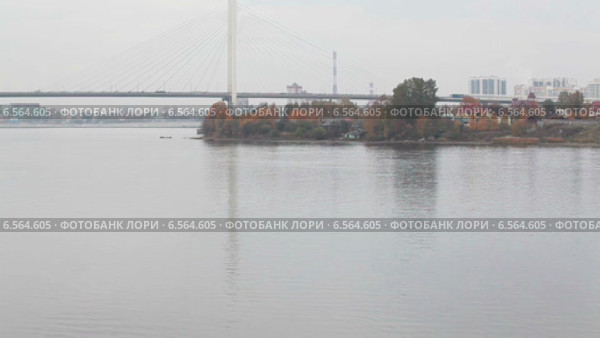 Рыбак ловит рыбу с моторной лодки на реке Неве напротив Большого Обуховского вантового моста, Санкт-Петербург. Стоковое видео, видеограф Кекяляйнен Андрей / Фотобанк Лори