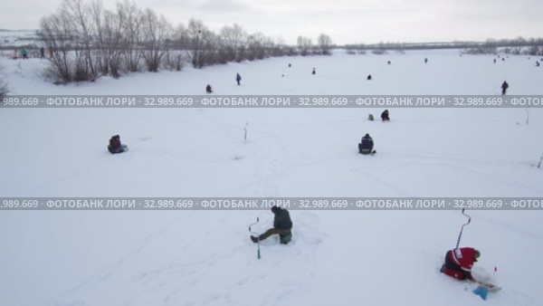 Рыбаки на льду. Соревнования по рыбалке с мормышкой со льда. Вид с воздуха. Fishermans on the ice. Competitions in fishing with jig from ice. Aerial view. Стоковое видео, видеограф Евгений Романов / Фотобанк Лори