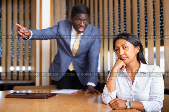 Saddened businesswoman sitting in office with dissatisfied male colleague. Стоковое фото, фотограф Яков Филимонов / Фотобанк Лори