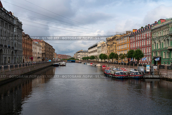 Saint Petersburg, Russia, July 21, 2024: View of the historical residential buildings on the Moika River embankment and the Blue Bridge. Редакционное фото, фотограф Ula Ulachka / Фотобанк Лори