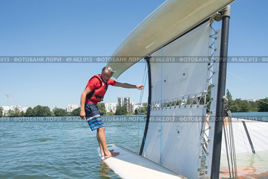 salior trying to right his catamaran after capsize. Стоковое фото, агентство Ingram Publishing / Фотобанк Лори