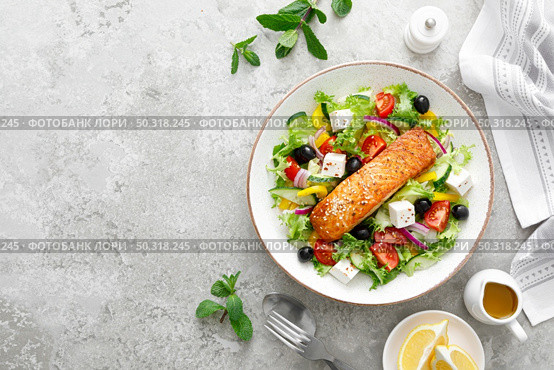 Salmon fish salad. Fresh vegetable greek salad with tomato, pepper, lettuce, olives, cucumbers, feta cheese and grilled salmon fish fillet in bowl, healthy food, omega 3, keto diet, mediterranean cusine, top view. Стоковое фото, агентство Ingram Publishing / Фотобанк Лори