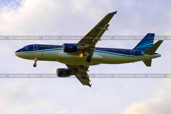 Самолет Airbus A320-200 "Курдамир" (4K-AZ84) авиакомпании AZAL Azerbaijan Аирлинес на фоне облачного неба перед посадкой в аэропрту Пулково (2016 год). Редакционное фото, фотограф Виктор Карасев / Фотобанк Лори