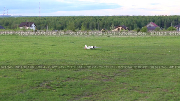 Самолет авиамодель приземляется на полевом аэродроме. Стоковое видео, видеограф Евгений Ткачёв / Фотобанк Лори