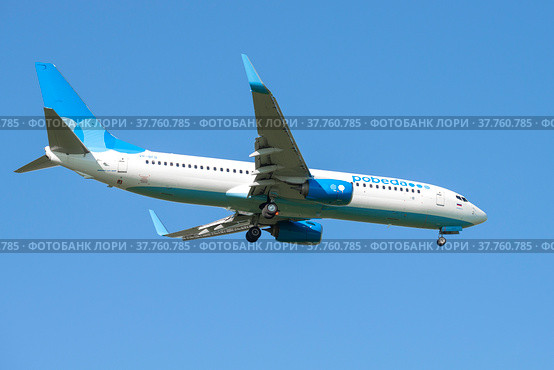 Самолет Boeing 737-800 (VP-BFB) авиакомпании "Победа" перед посадкой в голубом безоблачном небе (2021 год). Редакционное фото, фотограф Виктор Карасев / Фотобанк Лори