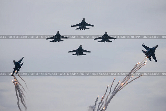 Самолеты Су-35С, отстреливающие тепловые ловушки, во время показательного полета. Стоковое фото, фотограф Сергей Бобылев / ТАСС / Фотобанк Лори
