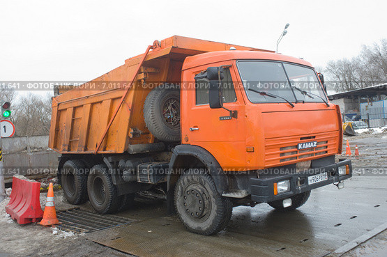 Самосвал КАМАЗ - 65115 около снегодробилки на снегоплавильном пункте, Москва (2015 год). Редакционное фото, фотограф Малышев Андрей / Фотобанк Лори
