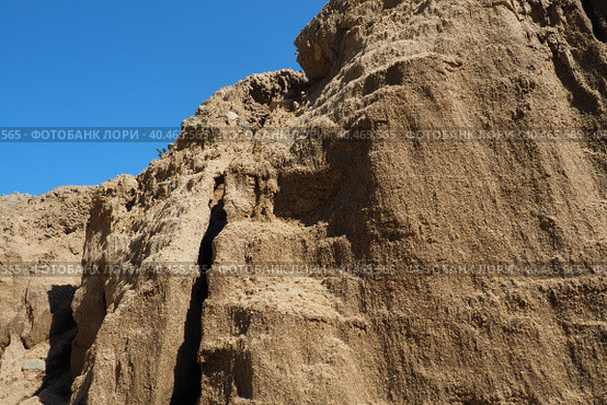 Sandstone is a fragmentary sedimentary rock, a homogeneous or layered aggregate of fragmentary grains and grains of sand bound by any mineral substance, cement. Quarry natural yellow sand wall. Стоковое фото, фотограф Юлия Петровская / Фотобанк Лори