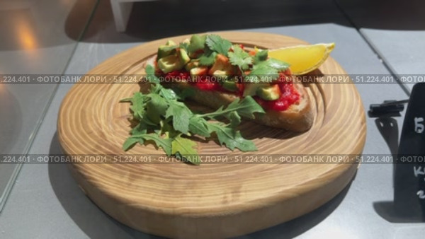 Sandwich with meat, herbs and avocado on a wooden stand in the restaurant. Стоковое видео, видеограф worker / Фотобанк Лори