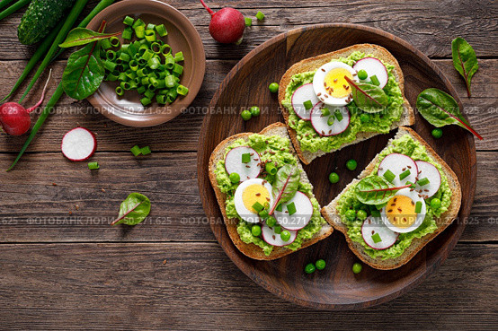 Sandwiches with wholemeal bread, hummus or puree of fresh green peas, radish, cucumber, boiled egg, green onion and chard. Стоковое фото, агентство Ingram Publishing / Фотобанк Лори