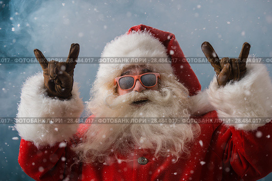 Santa Claus wearing sunglasses dancing outdoors at North Pole in snowfall. He is celebrating Christmas after hard work. Стоковое фото, фотограф Kirill Kedrinskiy / Ingram Publishing / Фотобанк Лори