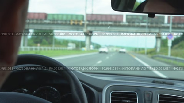 Scenic Highway Drive Captured During Daylight with a Clear View Ahead, Featuring Passing Vehicles and a Train Overpass in the Background. Стоковое видео, видеограф Владимир Федоров / Фотобанк Лори