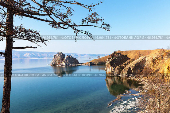 Scenic spring landscape of Baikal Lake on sunny May day. View from coast of Olkhon Island to the famous Shamanka Rock - natural landmark of lake. Natural background. Spring travels and outdoors. Стоковое фото, фотограф Виктория Катьянова / Фотобанк Лори