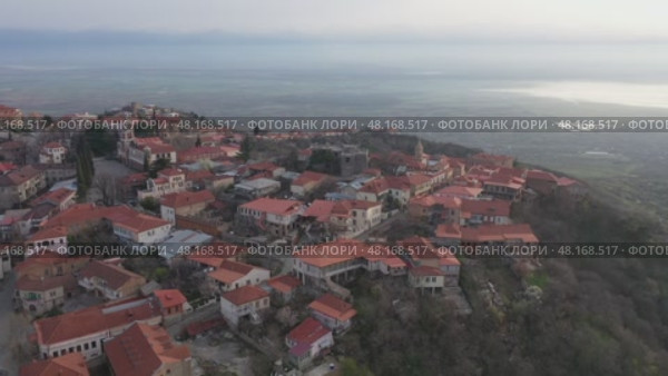 Scenic spring view from drone of Signagi township with narrow winding streets situated on hill in foothills of Gombori Range, Georgia. Стоковое видео, видеограф Яков Филимонов / Фотобанк Лори