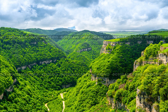 Scenic view of a deep green canyon with rocky walls in a mountainous area in cloudy weather. Стоковое фото, фотограф Константин Лабунский / Фотобанк Лори