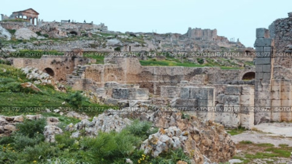 Scenic view of Licinius Sura Baths, well-preserved Roman ruins in Dougga, surrounded by spring greenery in Tunisia against cloudy backdrop. Стоковое видео, видеограф Яков Филимонов / Фотобанк Лори