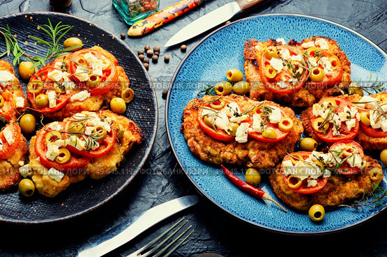 Schnitzel, breaded and fried thin layer of meat. Austrian dish. Schnitzel with olives and tomato. Стоковое фото, агентство Ingram Publishing / Фотобанк Лори
