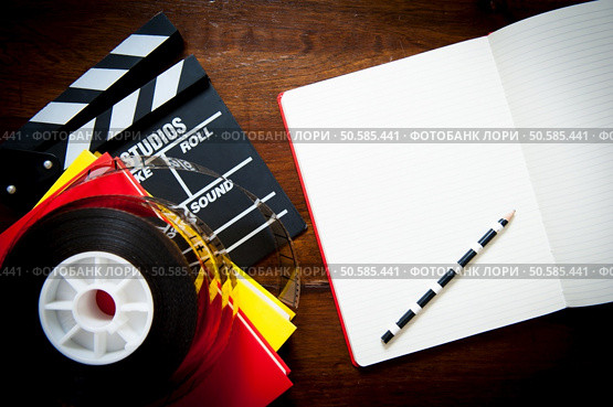 Screenwriter desktop detail with clapper, film reel notebook and pencil. Стоковое фото, агентство Ingram Publishing / Фотобанк Лори