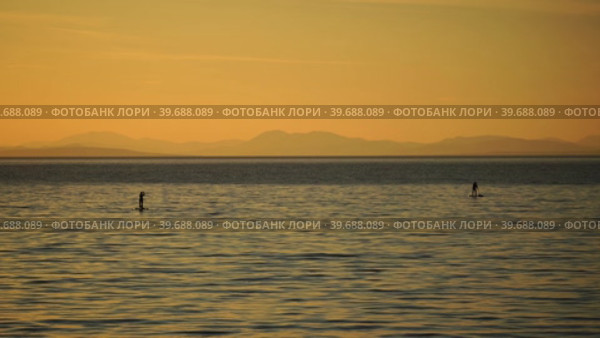 Sea landscape with silhouettes of the Islands and the people on the SAP boards. Стоковое видео, видеограф Виктория Кольцова / Фотобанк Лори