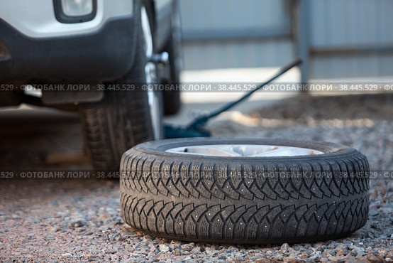 Seasonal winter wheels change. Snow tire lying on ground, is ready to install. Стоковое фото, фотограф Кекяляйнен Андрей / Фотобанк Лори