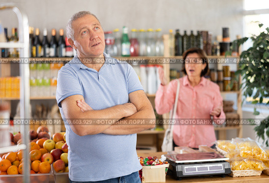 Senior wife stands behind pensioner husband and yells at companion. Стоковое фото, фотограф Яков Филимонов / Фотобанк Лори