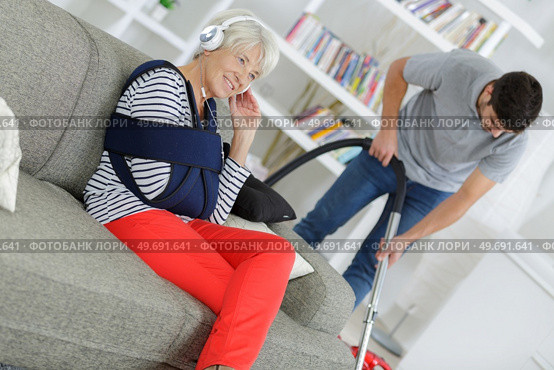 senior woman listens to music while his son is cleaning. Стоковое фото, агентство Ingram Publishing / Фотобанк Лори