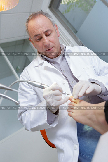 senior woman receives foot examination from gloved podiatrist. Стоковое фото, агентство Ingram Publishing / Фотобанк Лори