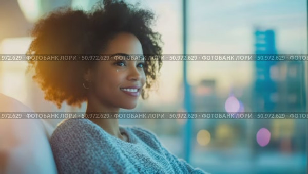 Serene portrait of a smiling woman with afro hair, gazing out of a window, illuminated by golden light, creating a peaceful and introspective mood. Стоковое AI-видео, аниматор Данила Большаков / Фотобанк Лори