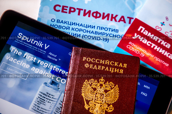 Сертификат о прохождении вакцинации от коронавирусной инфекции COVID-19 и сайт российской вакцины Sputnik V на планшете (2021 год). Редакционное фото, фотограф Николай Винокуров / Фотобанк Лори