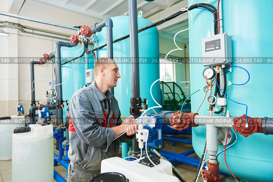 serviceman operating industrial water purification or filtration equipment. Стоковое фото, фотограф Дмитрий Калиновский / Фотобанк Лори