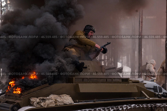 Sestroretsk, Russia - February 19, 2023: Amidst swirling smoke and flames, soldiers engage in fierce combat while restoring historical winter battle experiences inspired by the Second World War. Редакционное фото, фотограф Aleksandr Golubev / Фотобанк Лори
