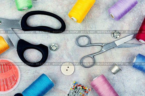Set sewing kit, scissors, threads, needles and colorful thread. Needlework concept. Top view, flat lay. Various sewing tools. Стоковое фото, агентство Ingram Publishing / Фотобанк Лори