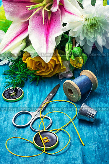 sewing accessories with bouquet of fresh flowers on turquoise background. Стоковое фото, агентство Ingram Publishing / Фотобанк Лори