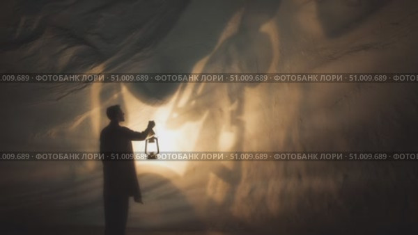 Shadow play in the cave with lantern light creates captivating silhouettes at dusk. Стоковое AI-видео, аниматор Сергей Толмачёв / Фотобанк Лори