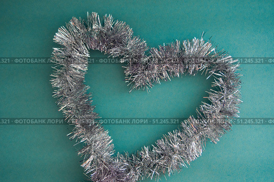 Shape of the heart of silver tinsel on a blue background, top view. Стоковое фото, фотограф Зарифа Арсланова / Фотобанк Лори