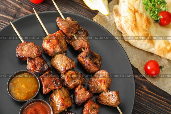 Шашлык из барбекю с сочным мясом и соусами на тарелке. Стоковое фото, фотограф Pixel_shot / Фотобанк Лори