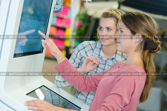 shop assistant helping customer to use touch screen. Стоковое фото, агентство Ingram Publishing / Фотобанк Лори