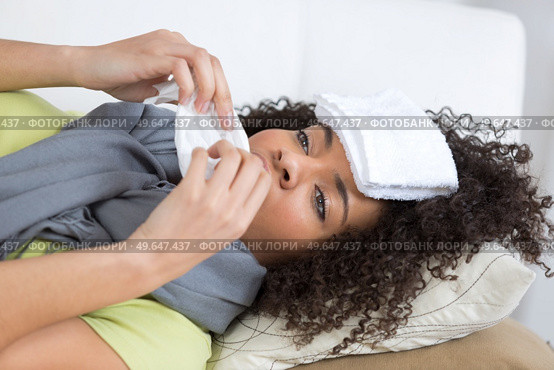 sick female suffering from migraine with wet towel on head. Стоковое фото, агентство Ingram Publishing / Фотобанк Лори