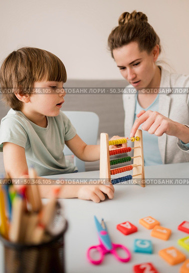 side view tutor teaching child how use abacus. Стоковое фото, агентство Ingram Publishing / Фотобанк Лори