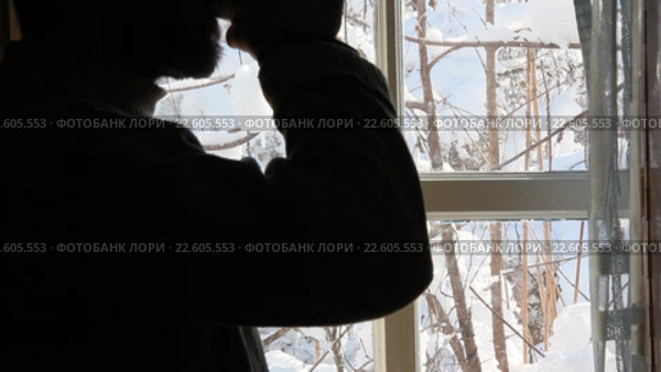 Силуэт мужчины с бородой, пьющего из чашки на фоне окна с сельским зимним пейзажем. Стоковое видео, видеограф Андрей С / Фотобанк Лори