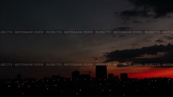 Силуэты городских зданий под небом с горяшей вечерней зорькой. Стоковое видео, видеограф Цыбин Вадим / Фотобанк Лори