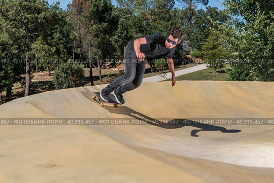 Skateboarder practice on a pump track park on a sunny summer day. Стоковое фото, агентство Ingram Publishing / Фотобанк Лори