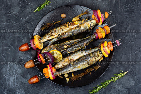 Skewers, of sardines roasting on an open fire. Typical dish on the Spanish Mediterranean. Fish kebab. Flat lay. Sea food barbecue. Стоковое фото, агентство Ingram Publishing / Фотобанк Лори